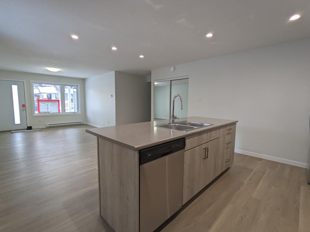 an empty kitchen with a sink and a counter top in a house