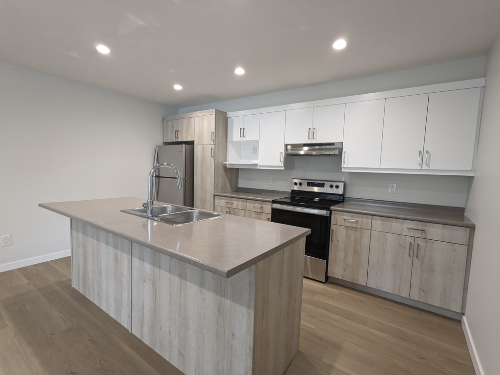 a kitchen with white cabinets and stainless steel appliances and a marble counter top