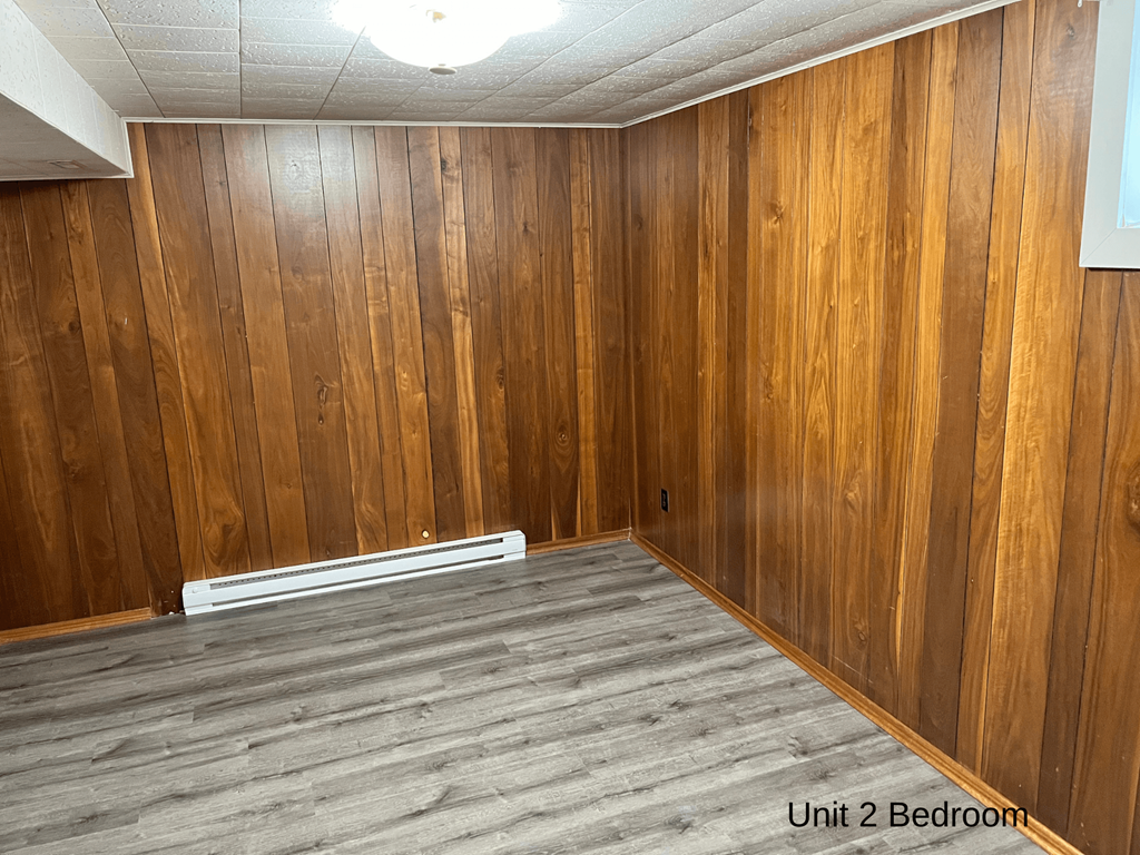 an empty room with wooden walls and a wood floor