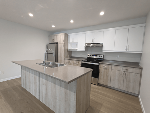 a kitchen with white cabinets and a marble counter top