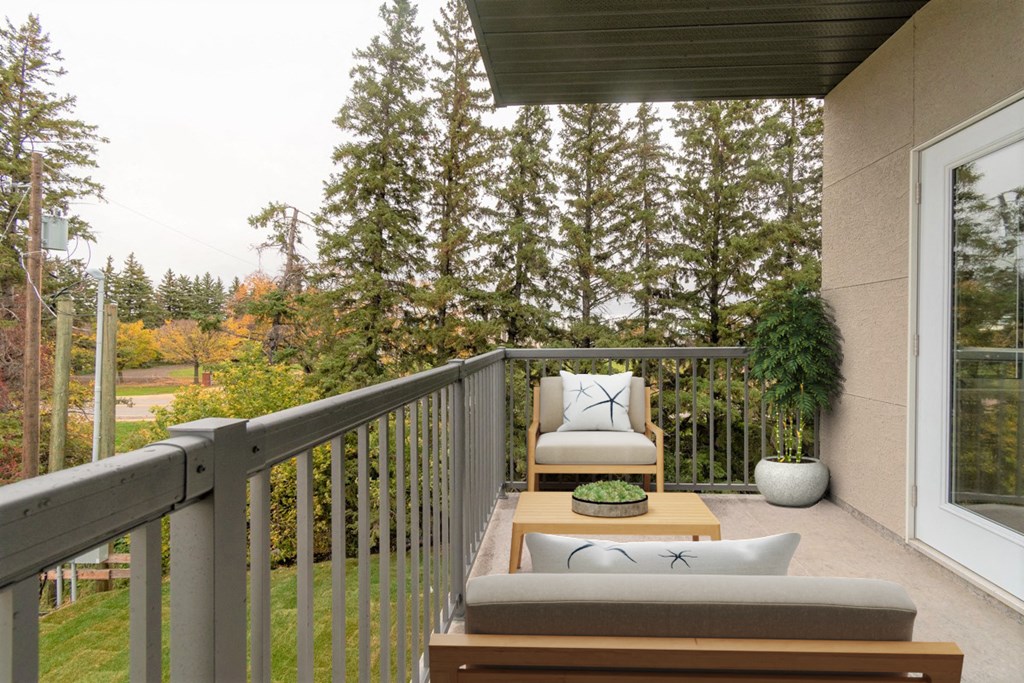 a patio with two chairs and a table on a balcony