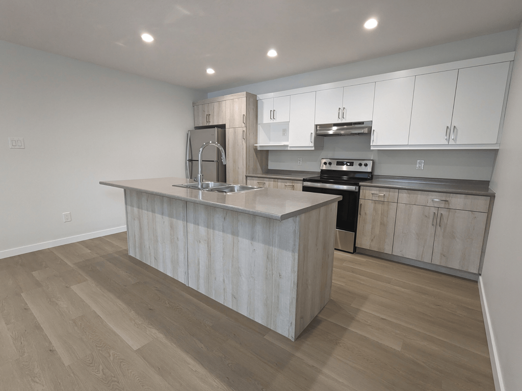 a kitchen with white cabinets and a large island with a sink