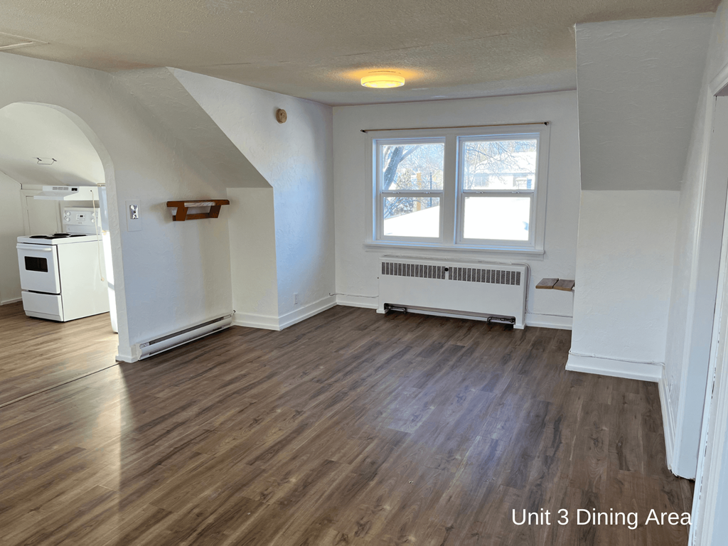 an empty living room with white walls and wooden floors