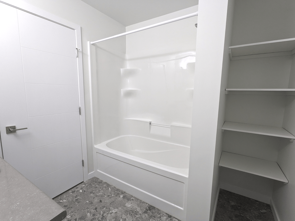a small white bathroom with a tub and a closet