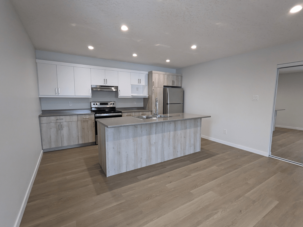 a kitchen with white cabinets and a large island in the middle