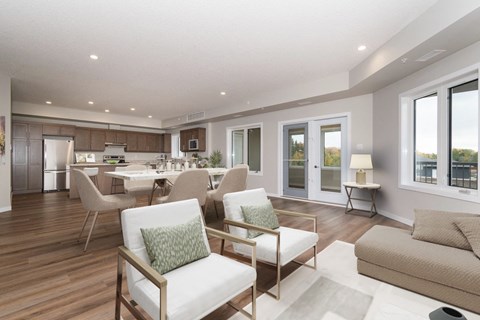 a living room with couches and chairs and a kitchen with a table