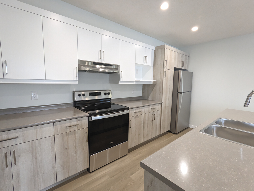 an empty kitchen with white cabinets and stainless steel appliances