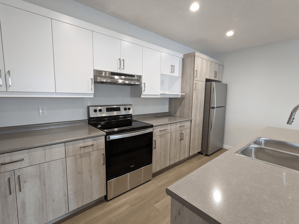 an empty kitchen with white cabinets and stainless steel appliances