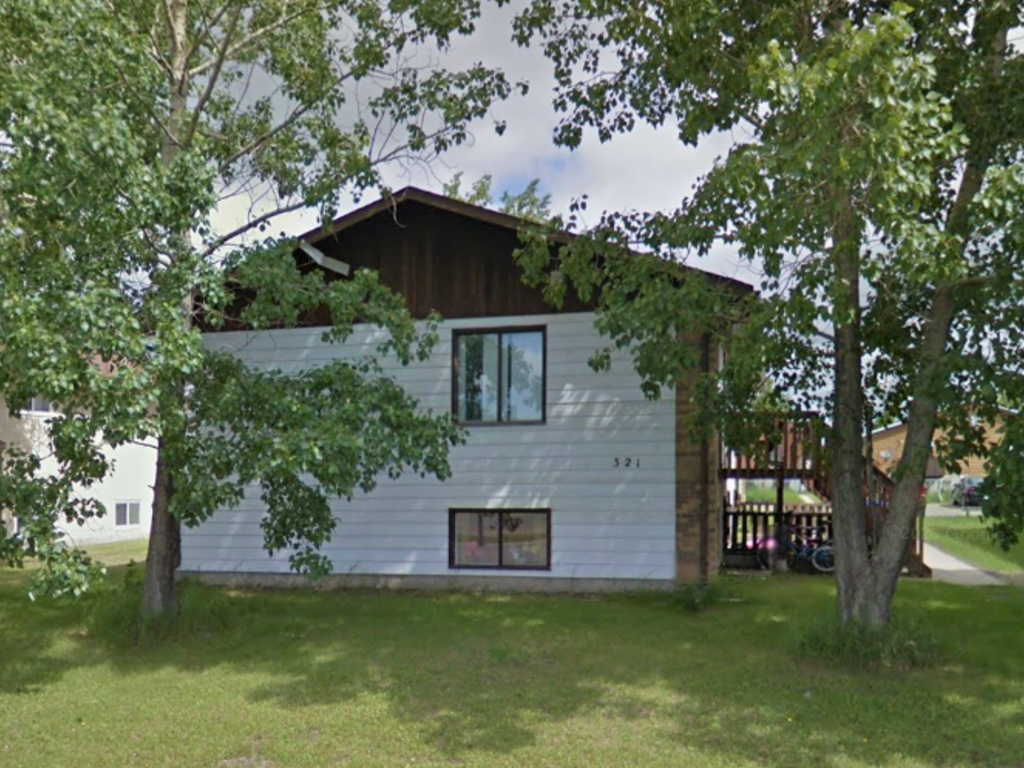 the front of the house with the trees