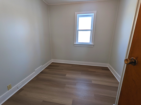 a empty room with wooden floors and a window