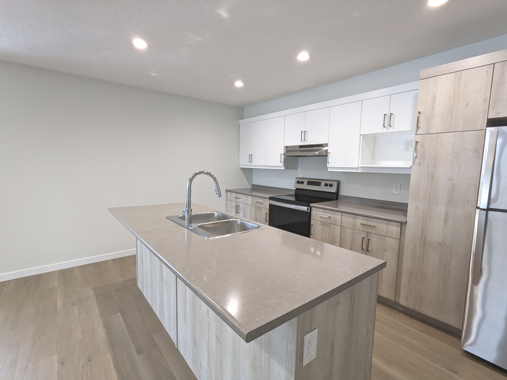 an empty kitchen with a sink and a counter top