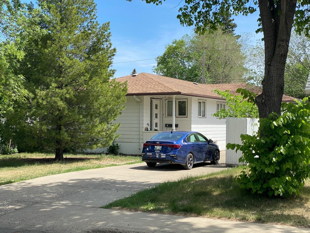 a blue car parked in front of a house