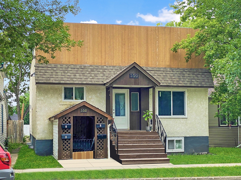 a tan house with a brown roof and stairs