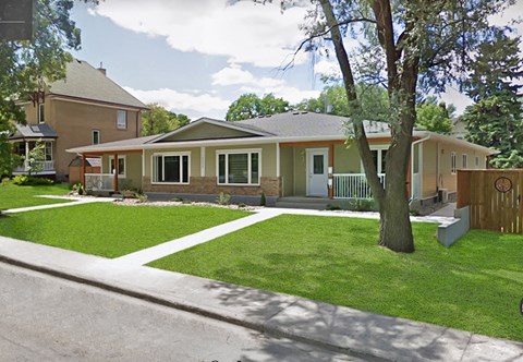 a house with a yard and a tree in front of it