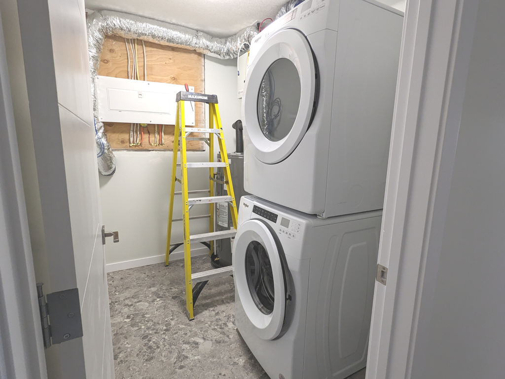 a washer and dryer in a laundry room with a ladder