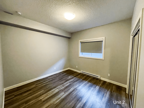 a living room with hardwood floors and a window