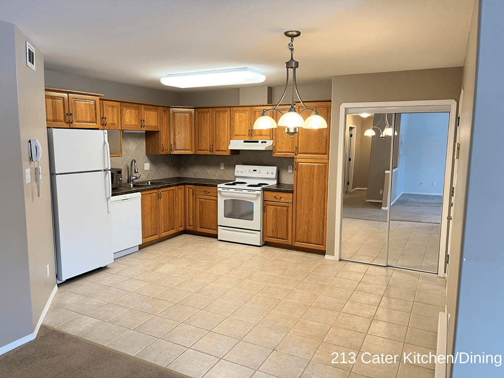 a kitchen with white appliances and wooden cabinets