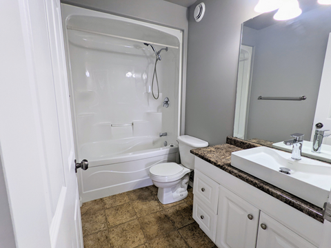 a bathroom with a shower and a sink and a toilet