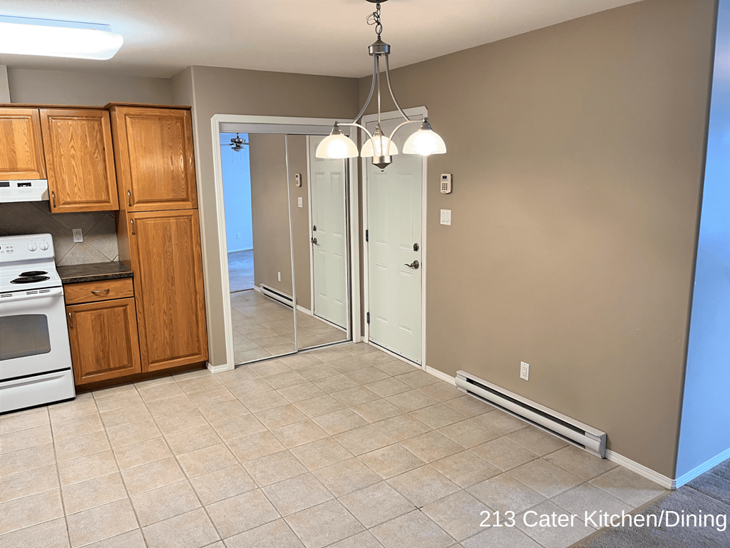 an empty kitchen and dining room with a chandelier
