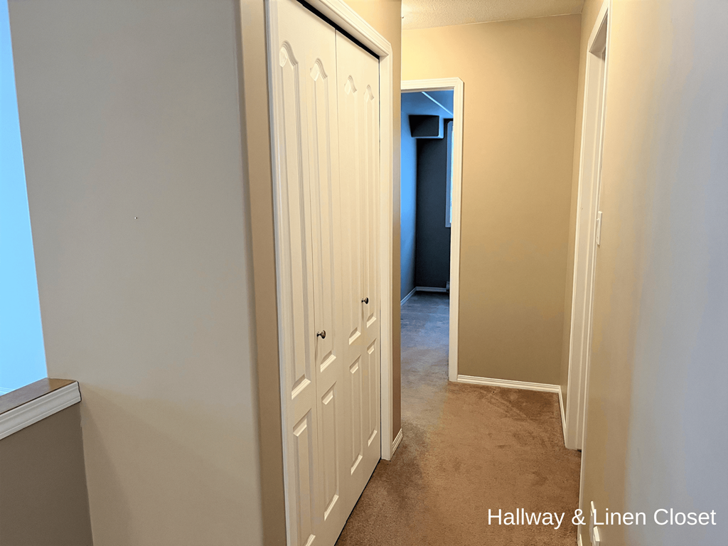 a hallway with two closets and a hallway closet and a door to a closet