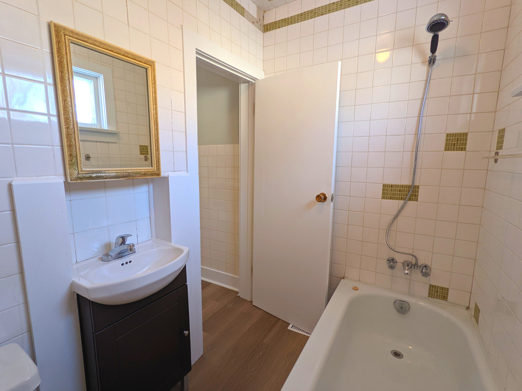a bathroom with a sink and a tub and a mirror