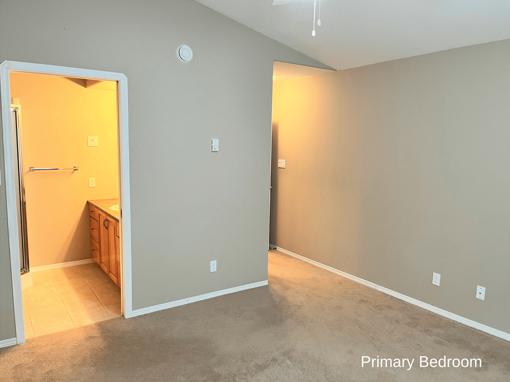 an empty room with a sink and a mirror in a house