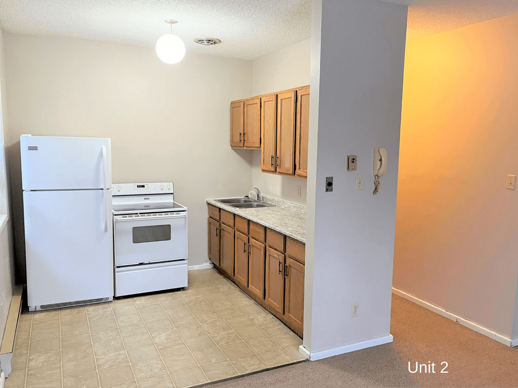 an empty kitchen with a stove refrigerator and sink