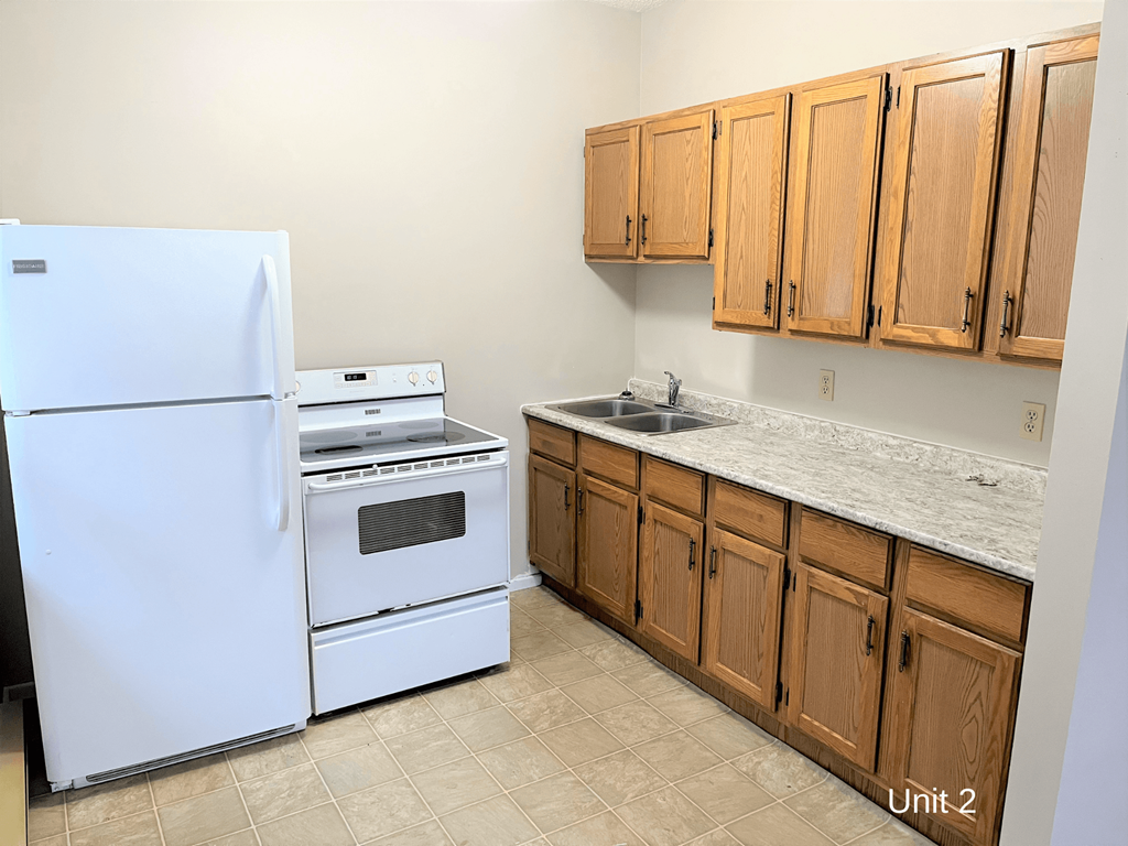 a kitchen with white appliances and wooden cabinets