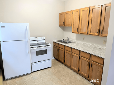 a kitchen with white appliances and wooden cabinets