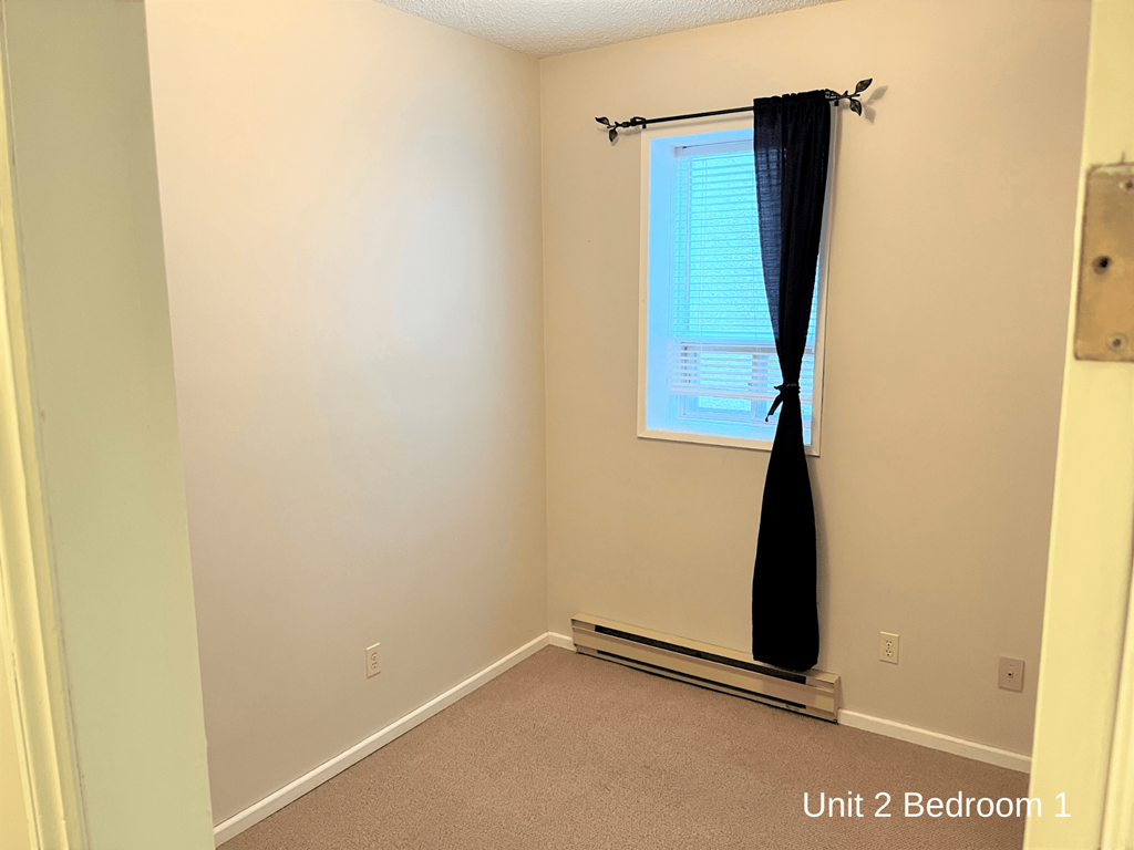 a small room with a window and a curtain