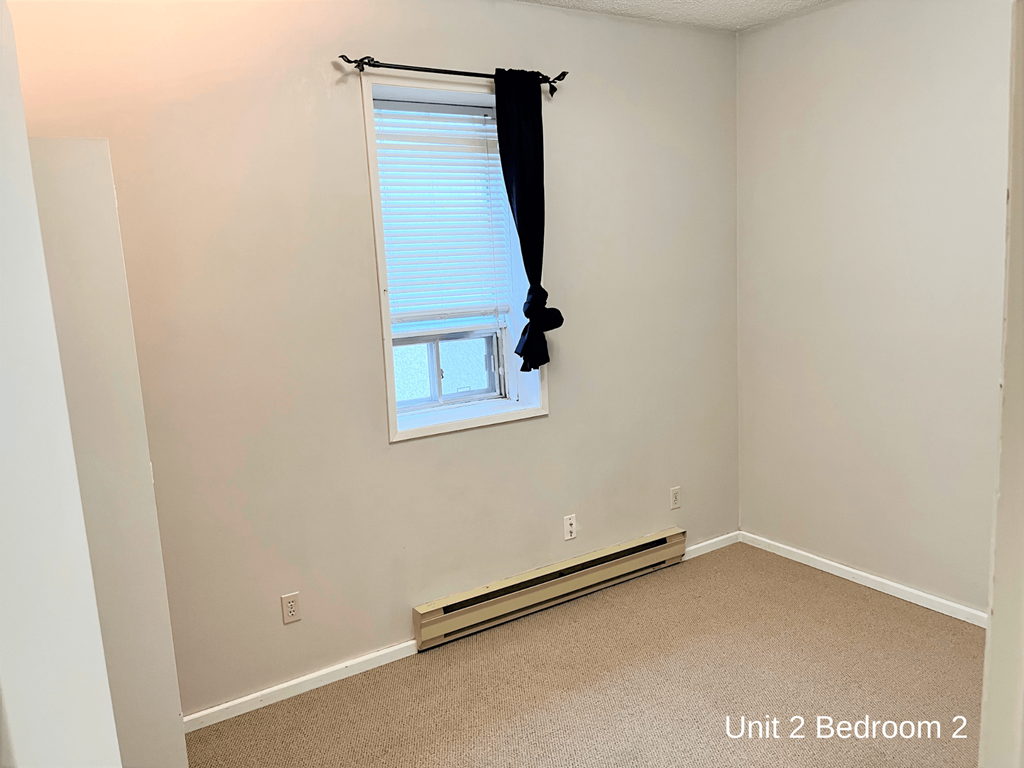 a small bedroom with a window and a window sill