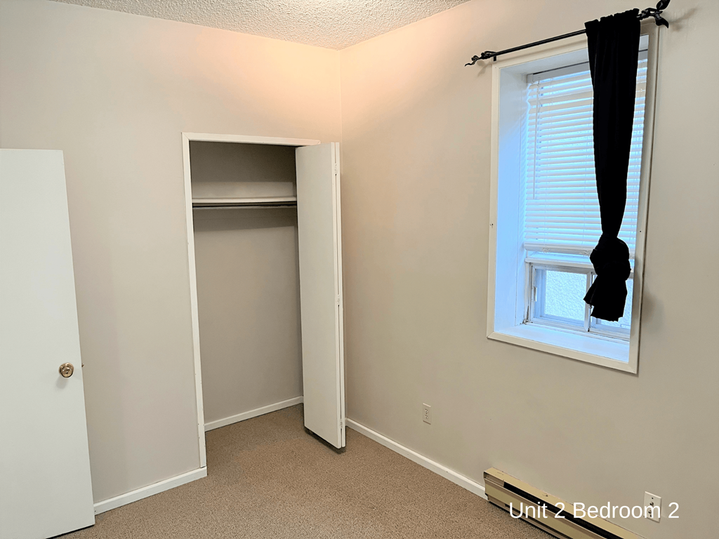 a small closet in a room with a window and a door