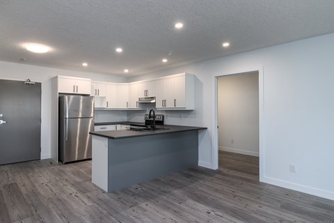 a kitchen with white cabinets and a stainless steel refrigerator