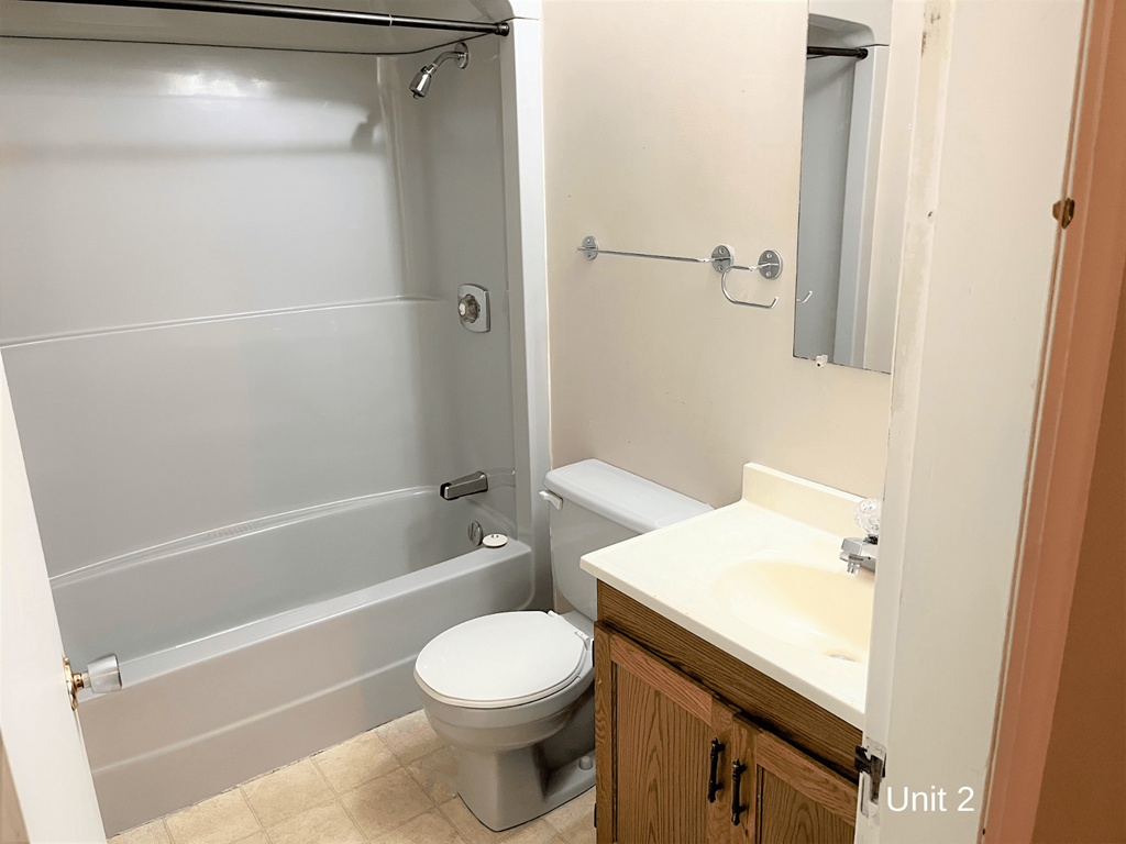 a bathroom with a toilet and a tub and a sink