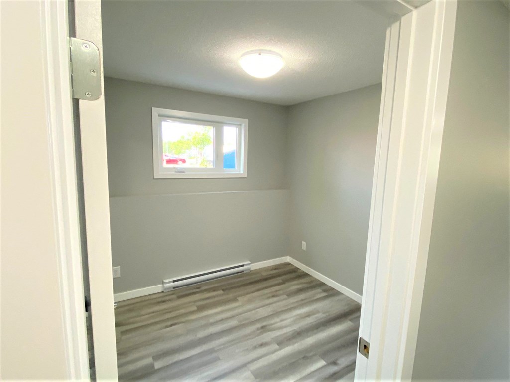 a room with a hard wood floor and a window
