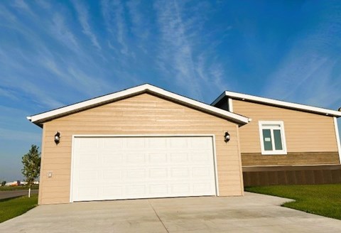 A house with a white garage door and a brown siding.