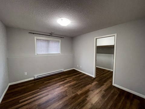 the interior of a bedroom with wood flooring and a closet
