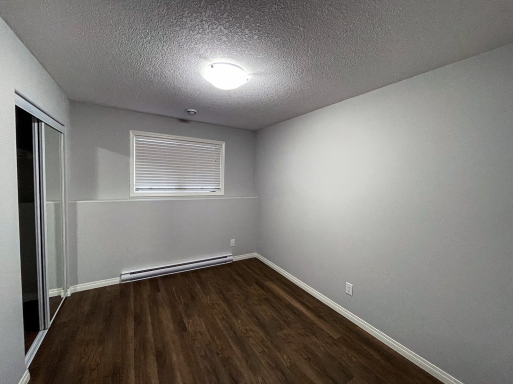 the interior of a living room with wood flooring and a window