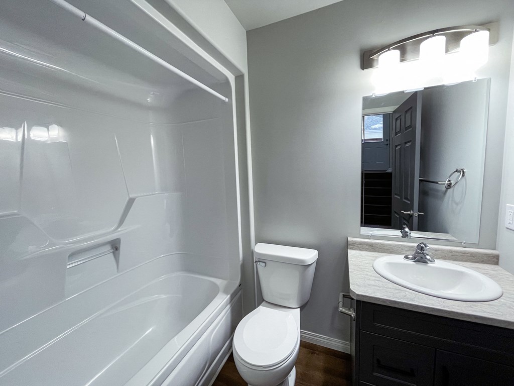 a bathroom with a toilet sink and tub and a mirror