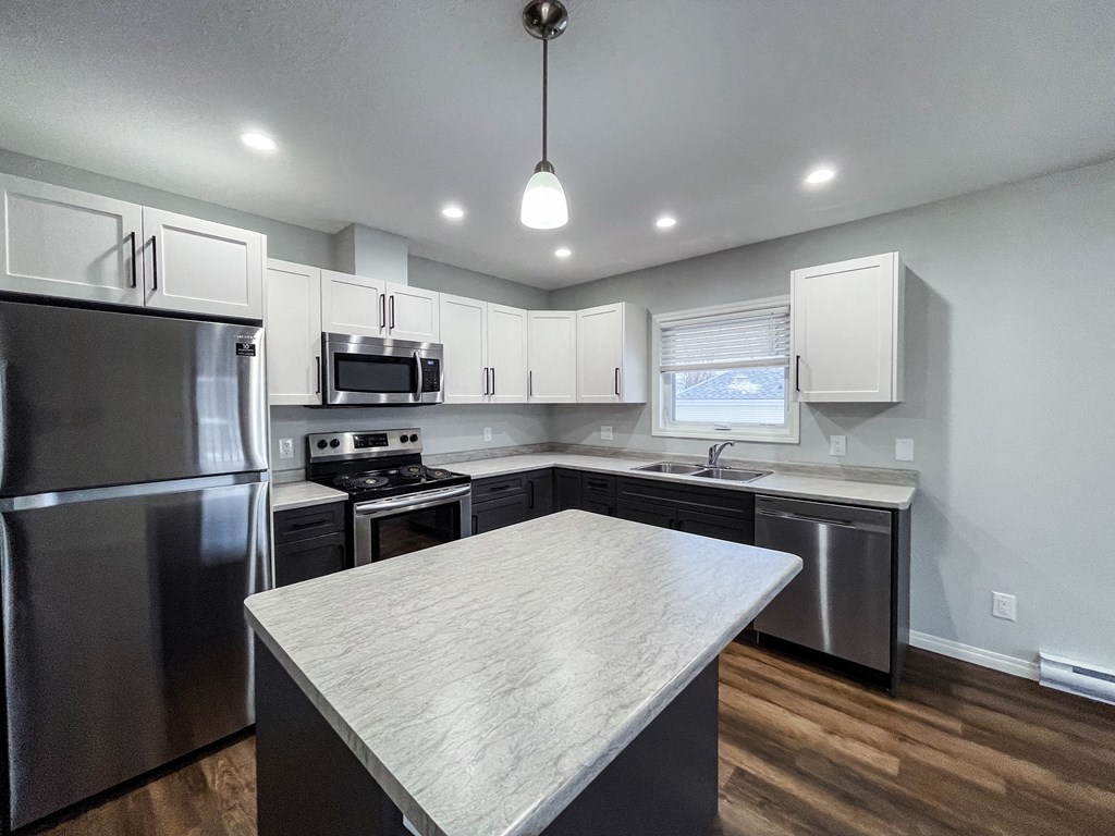 a kitchen with stainless steel appliances and a marble counter top