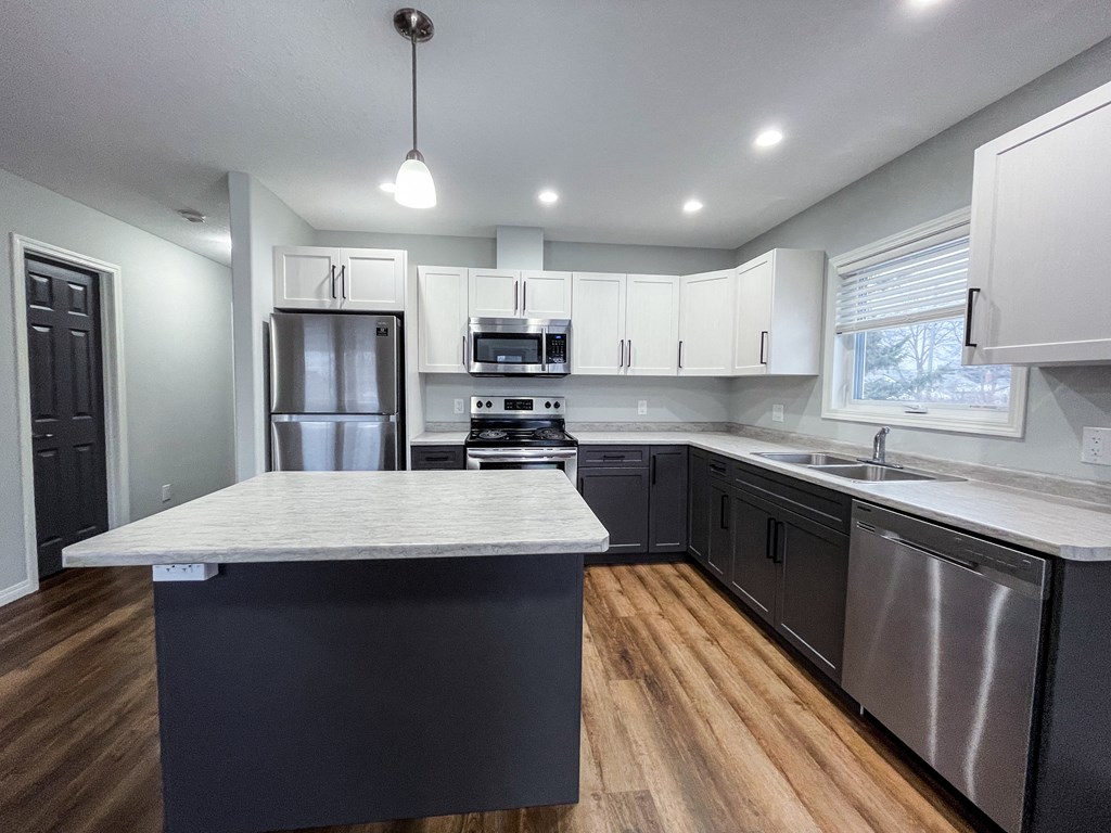 a kitchen with white cabinets and stainless steel appliances