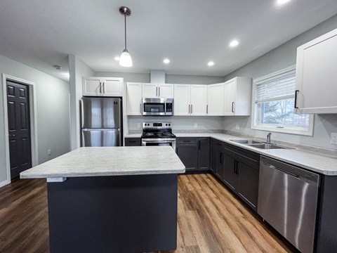 a kitchen with white cabinets and stainless steel appliances