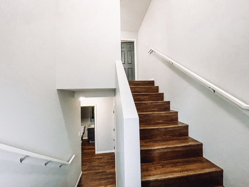 a staircase in a home with wood floors and white walls
