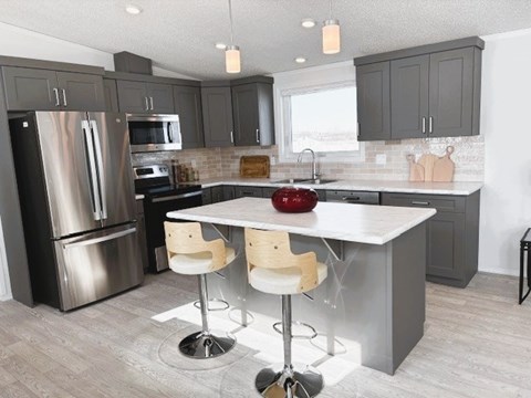 A modern kitchen with a large island and bar stools.