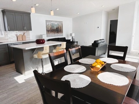A modern dining room with a wooden table set for six.