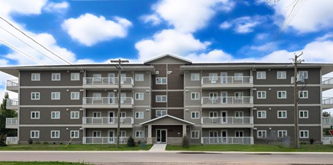 A large apartment building with a grey facade and balconies.