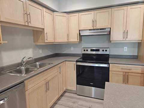 A kitchen with wooden cabinets and a black oven.