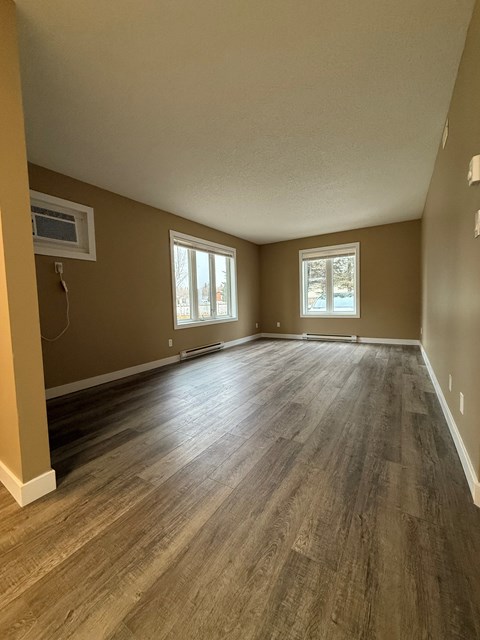 A room with brown walls and wood flooring.