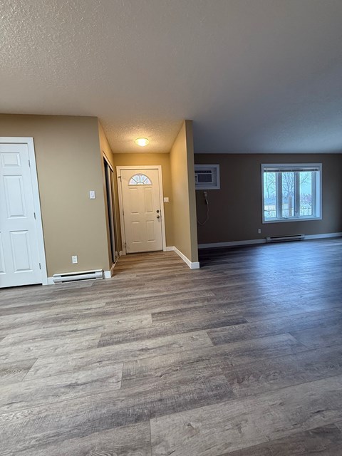 A room with a white door and a brown door with a window in the background.