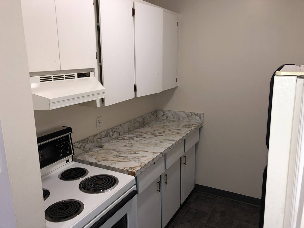 a kitchen with white cabinets and a stove